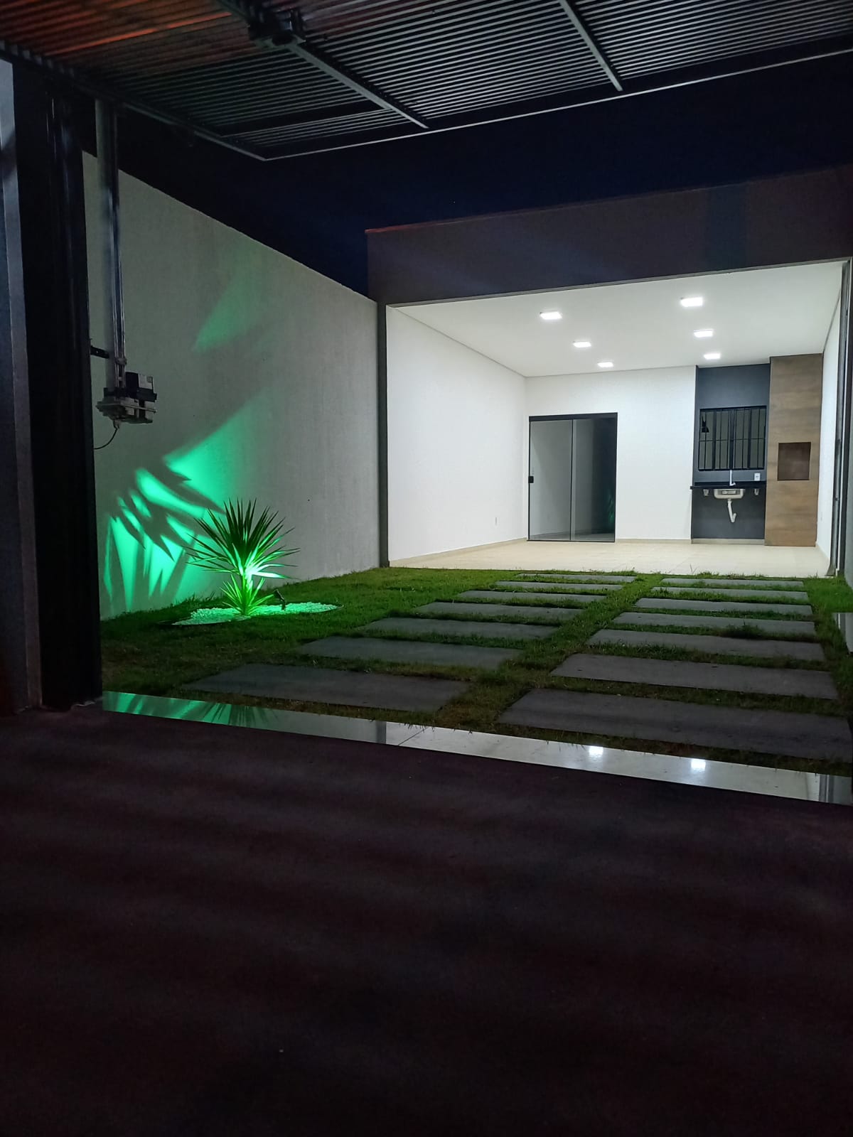 Fachada noturna com pedra e iluminação especial