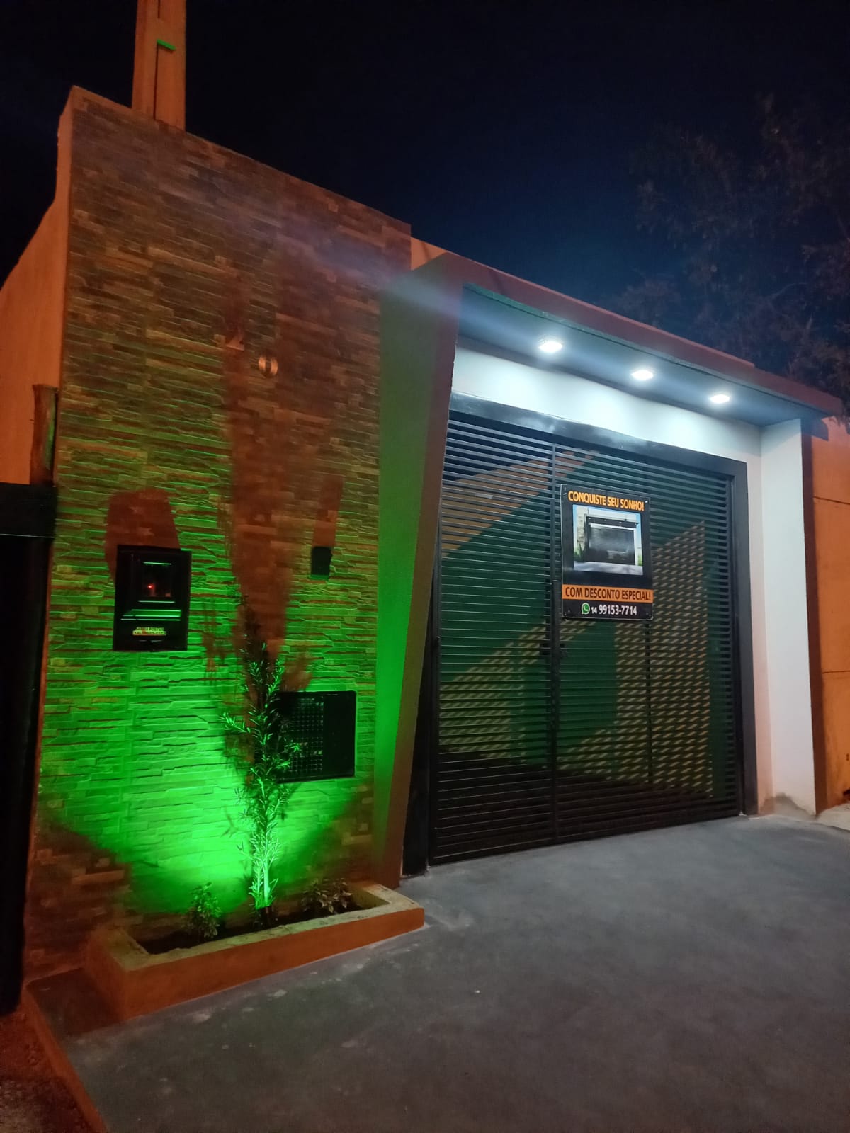 Área gourmet à noite com jardim iluminado