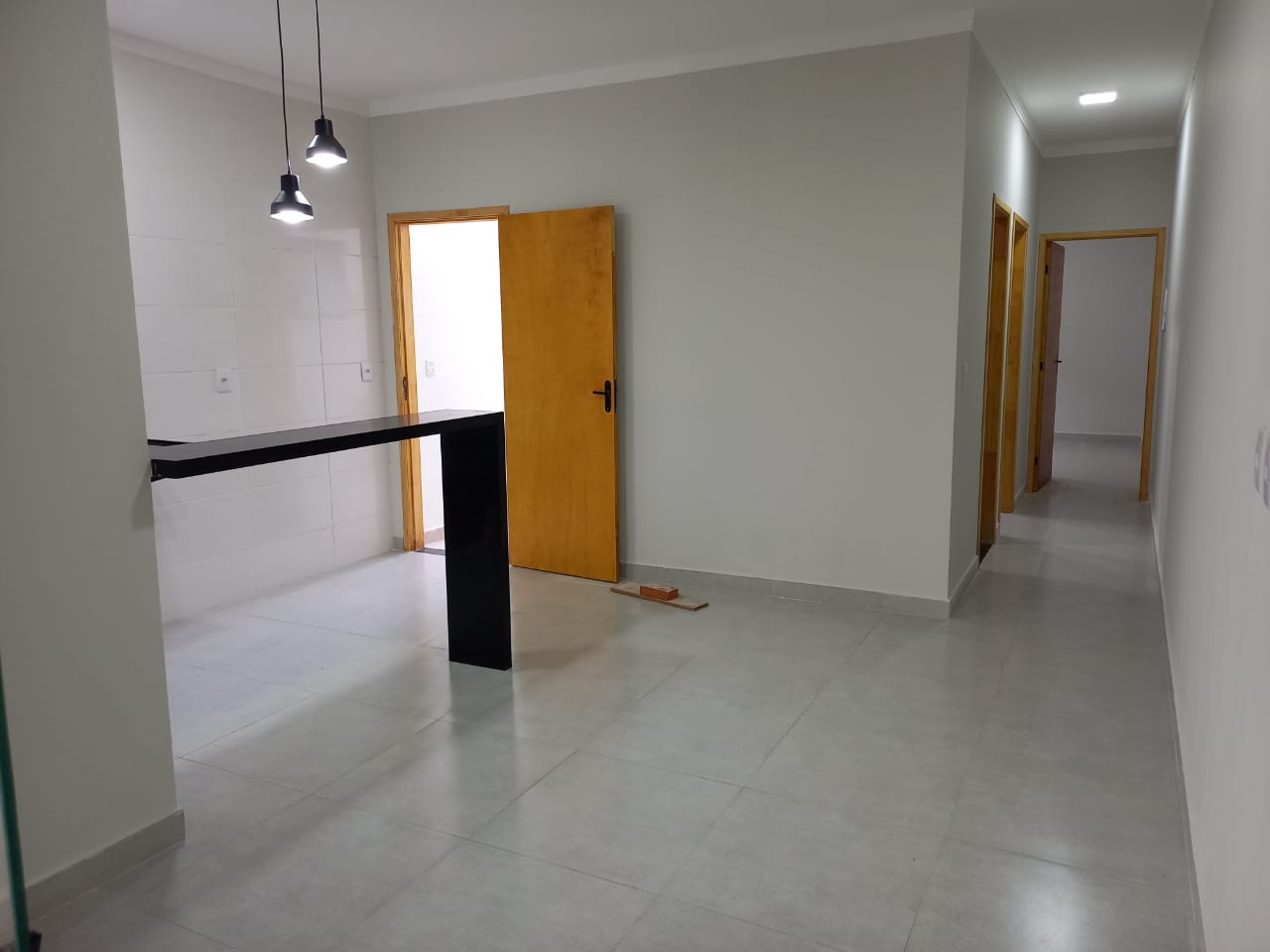 Cozinha americana com ilha e corredor de quartos